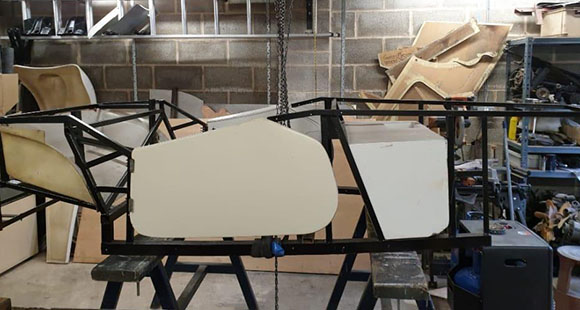 panel parts of a car being manufactured on a bare frame