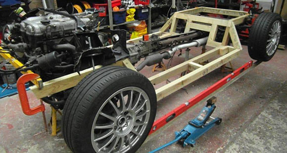 the bare chassis of a classic car undergoing repairs