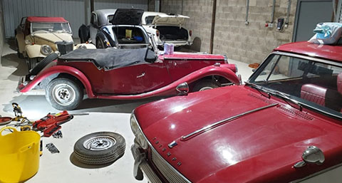 a number of classic cars in a workshop