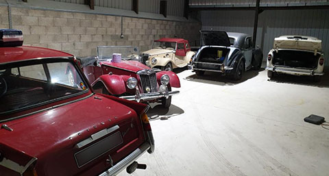 five cars in the midst of being restored in HRClassics workshop